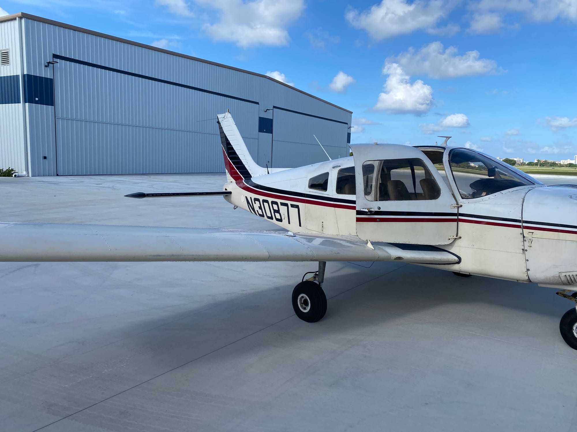 A Piper PA-28 Archer parked on the ramp outside Islander Aviation's hangar